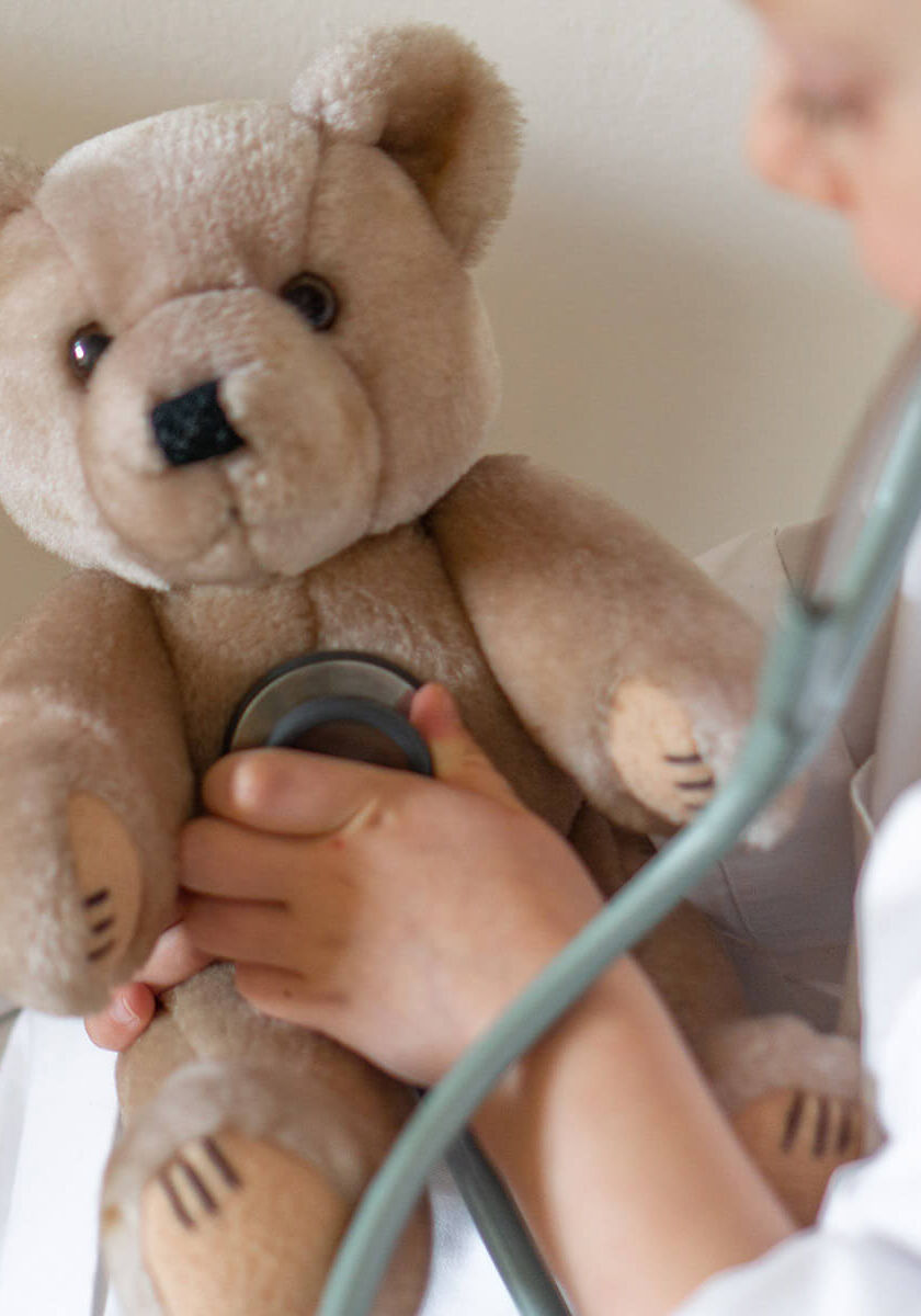 child listening to teddy bear's heartbeat